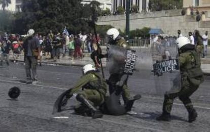 Policías antidisturbios reducen a un manifestante durante los choques violentos de hoy, en Atenas, entre manifestantes y las fuerzas de seguridad ocurridos durante una manifestación con motivo de la huelga general de 24 horas que vive Grecia.