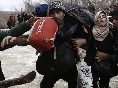 Refugiados intentan cruzar la frontera entre Grecia y Macedonia.