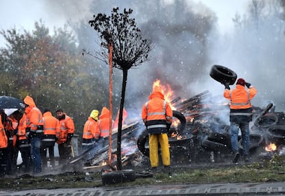 Un grupo de empleados de una empresa de acero bloquean una rotonda y queman basura a la entrada del lugar en Saint-Saulve, al norte de Francia.