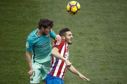 El defensa del FC Barcelona Sergi Roberto cabecea el balón ante el centrocampista del Atlético de Madrid Koke.