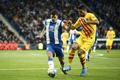 El delantero del Barcelona, Luis Suárez, trata de quitarle el balón a Javi López, del Espanyol