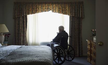 Un hombre en silla de ruedas en su habitaci&oacute;n.