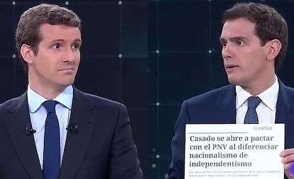 Albert Rivera (Ciudadanos) muestra a Pablo Casado (Partido Popular) un recorte de prensa en el que el líder de los populares se abre a pactar con el PNV.