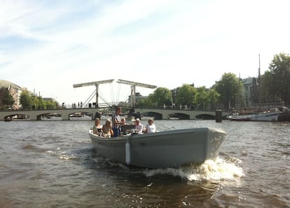 El Magere Brug, o puente flaco, sobre el río Amstel, con un bote de recreo. A la izquierda se puede ver el Teatro Carré.