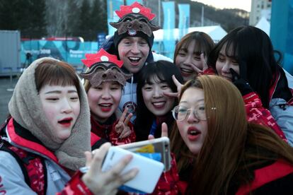 Un atleta estadoundense posa con un grupo de voluntarias en la Villa Olímpica de PyeongChang (Corea del Sur).
