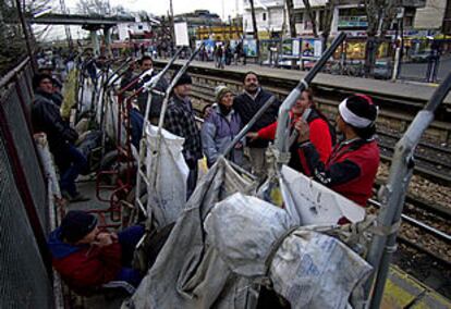 Un grupo de cartoneros aguarda la llegada del Tren Blanco, que les llevará hasta el centro de Buenos Aires para recoger papel.