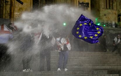 La policía utiliza cañones de agua para dispersar a los manifestantes que protestan frente al edificio del Parlamento en Tbilisi.