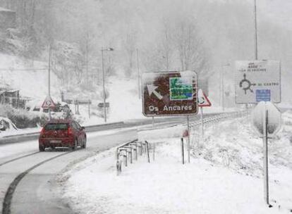 Un vehículo circula por una vía de entrada al Parque Natural de Ancares desde Lugo durante el temporal de nieve y frío que llegó hoy a la región.