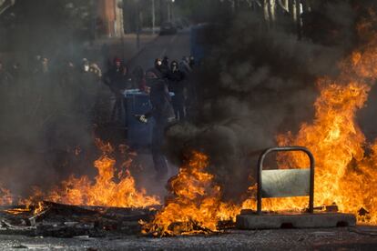 El segundo día de huelga en la universidad madrileña en defensa de la educación pública se ha saldado con 54 detenidos en la Complutense, uno de ellos en una barricada y el resto en el desalojo del edificio del Vicerrectorado, que había sido ocupado el pasado jueves. En la imagen, un joven lanza una botella durante la protesta.