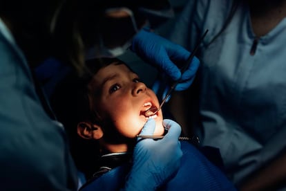 Dos dentistas examinan los dientes a un niño en una clínica en Madrid, en septiembre de 2019.