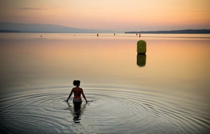 21 de julio de 2013. Una mujer se baña al amanecer en el lago Ginebra, Suiza.