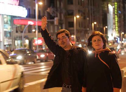 Una pareja de transeúntes intenta detener un taxi en la Gran Vía en la medianoche del pasado viernes.