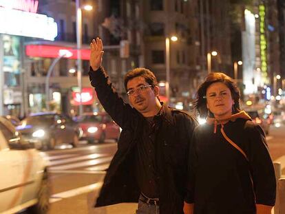 Una pareja de transeúntes intenta detener un taxi en la Gran Vía en la medianoche del pasado viernes.