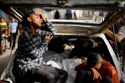 Dos jóvenes lloran durante el traslado de los cadáveres de sus familiares, víctimas de un bombardeo israelí en un campo de desplazados de Rafah, en el sur de la franja de Gaza, el 27 de mayo de 2024. 