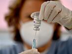 A health worker prepares a dose of the AstraZeneca/Oxford vaccine at a coronavirus vaccination centre at the Wizink Center in Madrid on May 12, 2021. - With nearly 79,000 deaths and more than 3.5 million infections, Spain has been badly hit by the pandemic. (Photo by GABRIEL BOUYS / AFP)