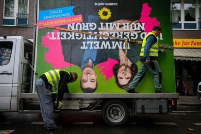 Empleados retiran una valla publicitaria de la campaña electoral del partido de los Verdes de Alemania con los retratos de los principales candidatos Katrin Goering-Eckardt y Cem Oezdemir.