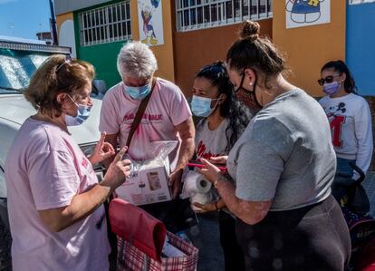 Voluntarios del Proyecto Vecinal de Alimentos de Mogán Nabohjelpen entregan alimentos a una familia canaria que ayuda a unos jóvenes migrantes africanos en Arguineguín, Gran Canaria.
