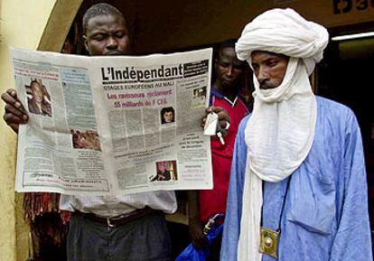Un hombre lee un periódico en Bamako, capital de Malí, que informa sobre los turistas secuestrados.