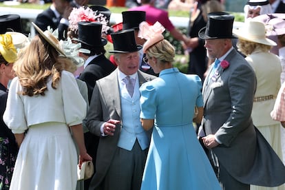 A la espera de confirmarse si este año asistirán Guillermo de Inglaterra y Kate Middleton tras su ausencia del año pasado, al inicio de Ascot también ha acudido la jinete británica Zara Tindall —única hija de la princesa Ana— y su marido, el jugador de rugby Mike Tindall. En la imagen, Carlos de Inglaterra saluda a su sobrina (con un vestido azul) y al deportista antes del inicio de las carreras del día.