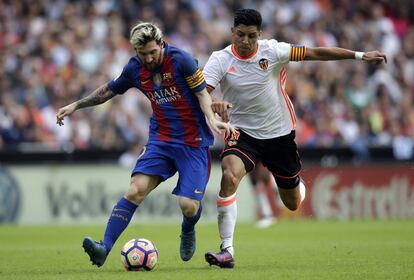 Lionel Messi (izquierda) del FC Barcelona y Enzo Pérez del Valencia CF luchan por el balón.