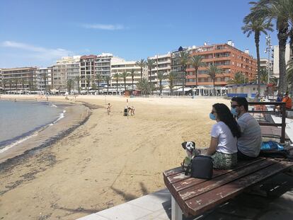 Una pareja, en la playa de Torrevieja, municipio alicantino donde priman las segundas residencias.