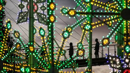 Dos personas observan la instalación de luces navideñas en Singapur.