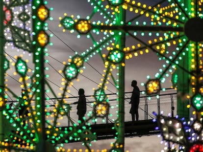 Dos personas observan la instalación de luces navideñas en Singapur.