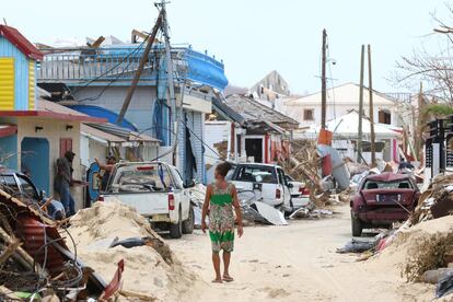 En la imagen, una mujer camina por una calle de Grande Case (San Martín), rodeada por los destrozos causados por el huracán Irma.