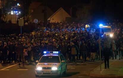 Cientos de personas, flanqueados por la policía eslovena, camina por una calle de Sentilj, cerca de la frontera con Austria.