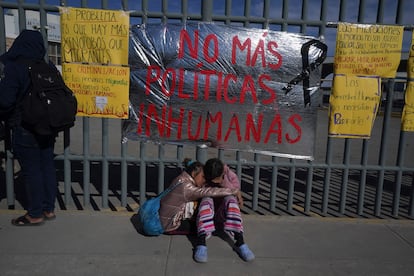 Dos mujeres venezolanas, hermanas, sentadas en la banqueta afuera del centro del INM.