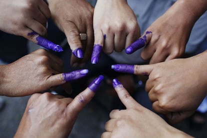 Venezolanos posan con sus dedos manchados de tinta después de votar por el sucesor del difunto presidente Hugo Chávez, en Caracas.