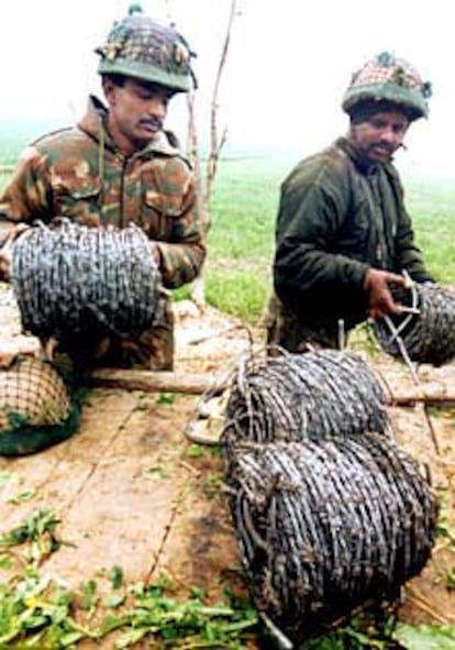 Soldados indios reparan una alambrada en la frontera paquistaní.