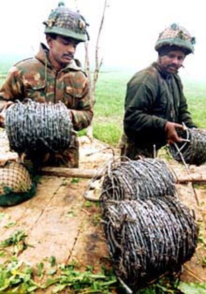 Soldados indios reparan una alambrada en la frontera paquistaní.