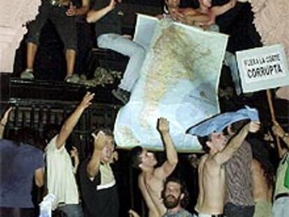 Unos manifestantes subidos en la puerta principal de la Casa Rosada.