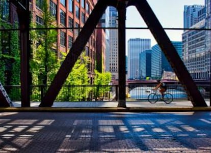 Un ciclista cruzando una calle del Loop, en Chicago (EE UU), con el río homónimo al fondo.