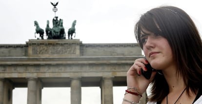 Una mujer habla por tel&eacute;fono frente a la Puerta de Brandemburgo, en Berl&iacute;n.