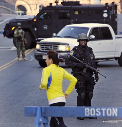 Una corredora pasa junto a un control policial que bloquea una calle que conduce a la ruta del maratón de Boston (Estados Unidos). El número de heridos causados por los atentados cometidos durante la maratón ha subido a 176, de los que 17 permanecen en estado crítico.