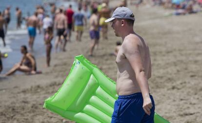 Un bañista se dirige al agua en la playa de la Misericordia, en Málaga.