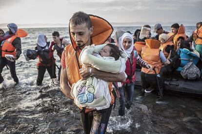 Un grupo de refugiados desciende de una barca de plástico tras cruzar el Mar Egeo. Según Acnur, el 37% de los refugiados llegados a Europa tras cruzar el Mediterráneo son niños.