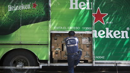 Un trabajador cierra la puerta de un camión repartidor de cervezas, en Ciudad de México