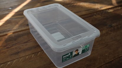 Cajas de plástico para almacenamiento sobre una mesa de madera.