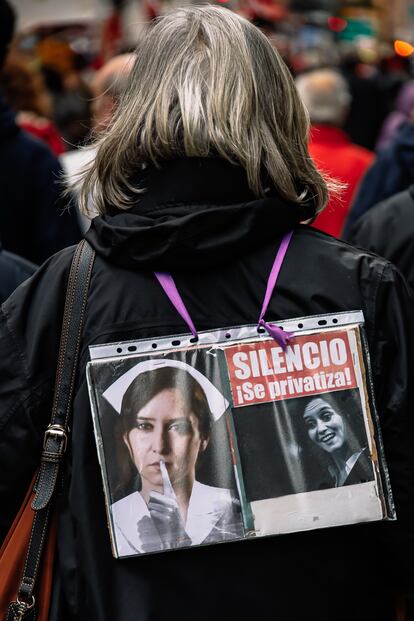 Una manifestante contra la Ley Ómnibus, con un cartel con la imagen de Ayuso que dice 'Silencio se Privatiza', el 26 de febrero.