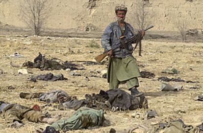 Un combatiente de la Alianza del Norte pisa un cuerpo mientras camina por el patio de la fortaleza  de  Qala-i-Janghi.
