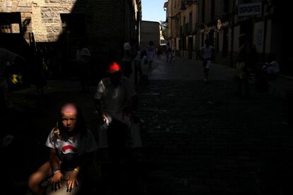 La gente toma un descanso durante la "Comparsa de gigantes y cabezudos" del festival de San Fermín, en Pamplona.