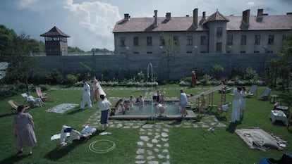 Scene from 'The Zone of Interest' in the garden of the Auschwitz commander's with the extermination camp in the background.