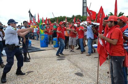 Policial usa arma de choque contra sem-terra em protesto.