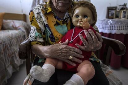 Manoli, de 89 años de edad, posa con su muñeco llamado Daniel, lo compró hace 50 años con el dinero que iba ahorrando todos los meses, ya que de niña no pudo tener juguetes. Llegó a Fontilles en 1949, antes trabajaba en un taller de modista pero fue despedida cuando le diagnosticaron la enfermedad. Ahora oculta su rostro a la cámara por temor a que los amigos de su hermano le den de lado si se llegan a enterar. 