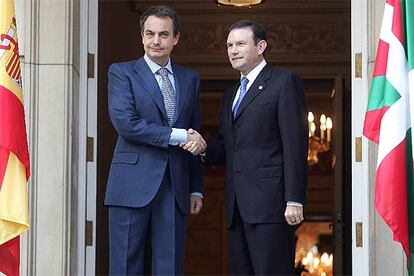 José Luis Rodríguez Zapatero recibe a Juan José Ibarretxe en la puerta de La Moncloa, flanqueda por las banderas de España y Euskadi.