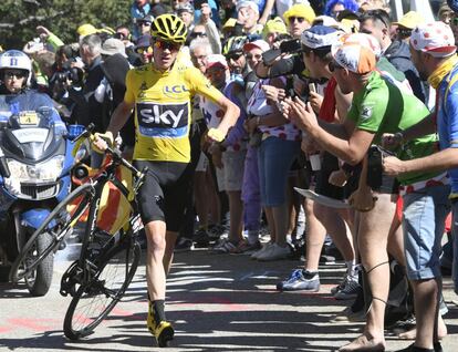 El británico Chris Froome, corre sujetando su bicicleta después de una caída en la duodécima etapa del Tour de Francia.
