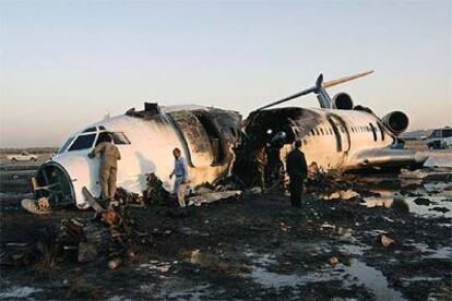 Técnicos iraníes trabajan sobre los restos del avión siniestrado ayer en Mashad, al noreste de Irán.